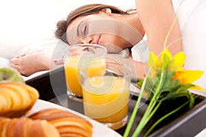 Beautiful woman with breakfast in bed