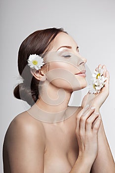 Beautiful Woman Breathes Camomile Flowers.