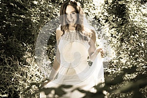 Beautiful woman, bride with blue eyes and brown hair walks through leafy woods, woodland on a bright sunny summer`s day