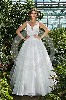Beautiful woman bride in long white wedding dress espousal fashion marriage celebration big day in green park garden backyard