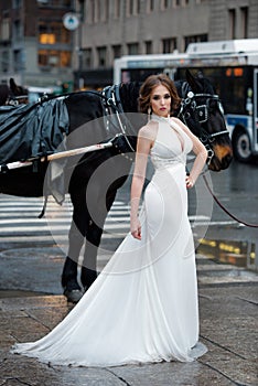 Beautiful woman bride in long white wedding dress posing in New York City street