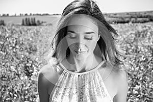 Beautiful woman, bride walks through crop field on a sunny summer`s day