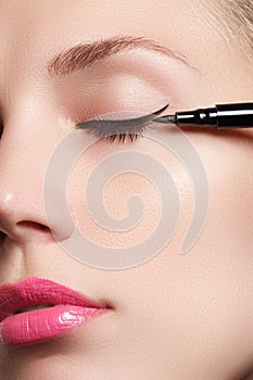 Beautiful woman with bright make up eye with black liner makeup. Fashion arrow shape. Chic evening make-up. Makeup beauty wit