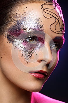 Beautiful woman with bright makeup with glitter