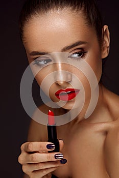 Beautiful Woman With Bright Red Lips And Lipstick In Hand