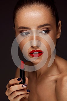 Beautiful Woman With Bright Red Lips And Lipstick In Hand