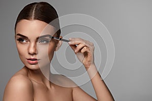 Beautiful Woman Brushing Eyebrows With Brow Tool photo