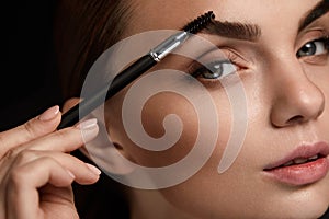 Beautiful Woman Brushing Eyebrows With Brush. Beauty