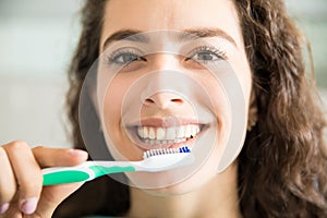 Beautiful Woman Brushing Teeth In Dental Clinic