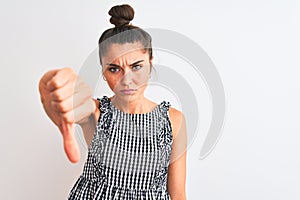 Beautiful woman with bun wearing casual dresss standing over isolated white background looking unhappy and angry showing rejection