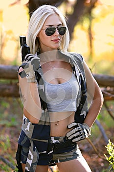 Beautiful woman in camouflage and gun