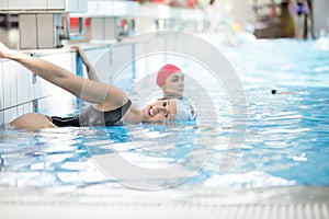 Beautiful woman cap smiling looking to camera at border of swimming pool