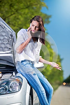 Beautiful woman with car trouble talking over phone