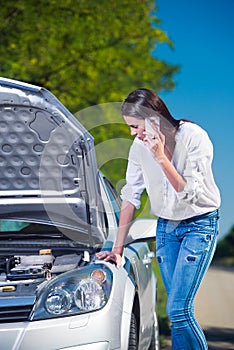 Beautiful woman with car trouble talking over phone