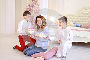 Beautiful woman and caring mother with two male children exchang