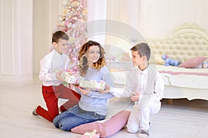 Beautiful woman and caring mother with two male children exchang
