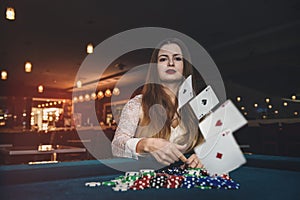 Beautiful woman in casino throwing playing cards