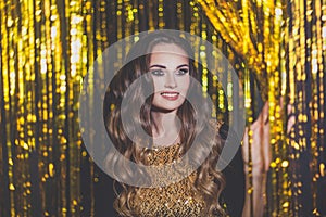 Beautiful woman celebrity entering the door to the party on golden bokeh background