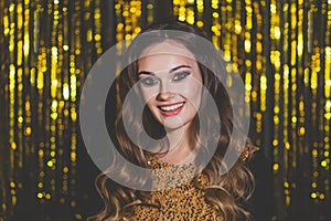 Beautiful woman celebrity with makeup on golden bokeh background