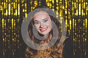 Beautiful woman celebrity with makeup on golden bokeh background.