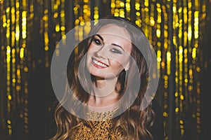 Beautiful woman celebrity with makeup on golden bokeh background