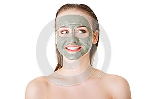 Beautiful woman with clay facial mask, isolated on white