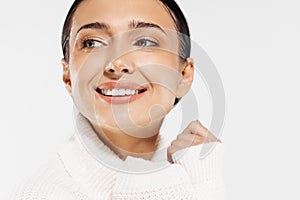 Beautiful woman with clean fresh skin smiling on a white background, beauty portrait of a female face with natural skin