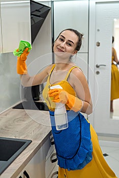 Beautiful woman cleaning her kitchen hood from dust