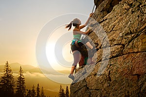 Mujer hermosa sobre el la roca sobre el brumoso atardecer en montanas. aventura a extremo deporte 