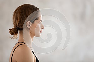 Beautiful woman with closed eyes practicing yoga, meditating, profile view