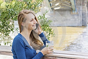 Beautiful Woman with cocktail in cafe mobile phone speaking.
