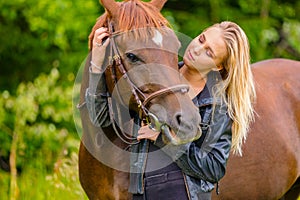 Beautiful woman communicate with her arabian horse in the field
