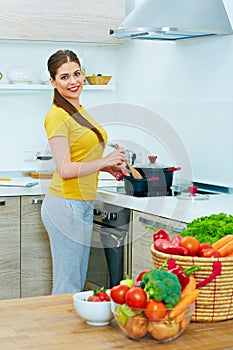 Beautiful woman cooking healthy food in home kitchen.