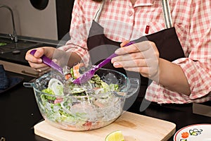 Beautiful woman cooking in new kitchen making healthy food with