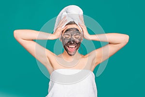 Beautiful woman with cosmetic mud facial procedure, spa health concept. Skin care beauty treatment. Towel on head