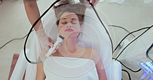 Beautiful woman at a cosmetologist& x27;s reception receives a vacuum massage of the skin of the face using a cosmetological