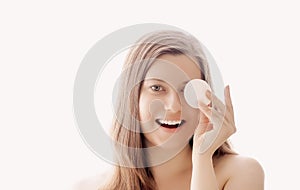 Beautiful woman with cotton pad, perfect skin and shiny hair as make-up, health and wellness concept. Face portrait of