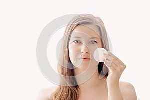 Beautiful woman with cotton pad, perfect skin and shiny hair as make-up, health and wellness concept. Face portrait of