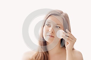 Beautiful woman with cotton pad, perfect skin and shiny hair as make-up, health and wellness concept. Face portrait of