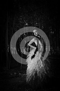 Beautiful woman in couture dress standing in a forest