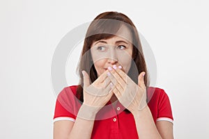 Beautiful woman covers her mouth with her hands for silent isolated. Red tshirt and keeping a secret.