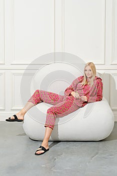 Beautiful woman in a cozy home suit half laying on couch
