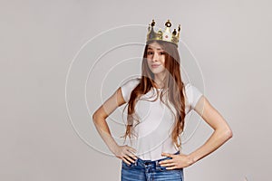 beautiful woman with crown on head keeping hands on hips, self-motivation and dreams to be best,