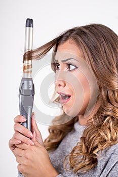 Beautiful woman with curling iron