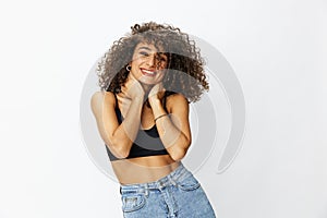 Beautiful woman with curly afro hair posing on a white  background smile happiness in jeans and black top