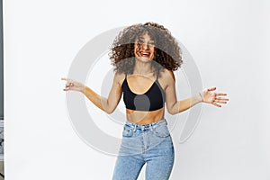 Beautiful woman with curly afro hair posing on a white  background smile happiness in jeans and black top