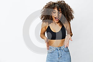 Beautiful woman with curly afro hair posing on a white  background smile happiness in jeans and black top