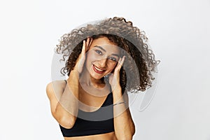 Beautiful woman with curly afro hair posing on a white  background smile happiness in jeans and black top