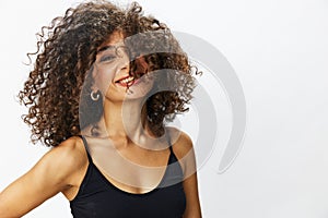 Beautiful woman with curly afro hair posing on a white isolated background smile happiness in jeans and black top