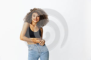 Beautiful woman with curly afro hair posing on a white isolated background smile happiness in jeans and black top